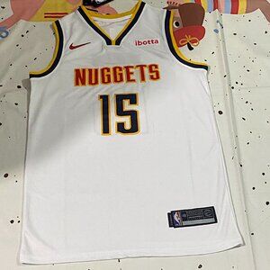 Denver Nuggets Player Jokić Wearing A White Jersey With The Number 15